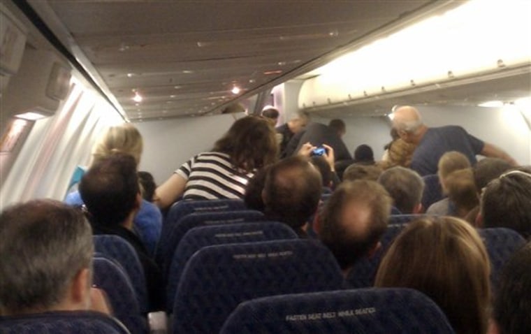 In this image captured by Andrew Wai, passengers aboard American Airlines Flight 1561 subdue a man identified as Rageh Al-Murisi on Sunday as the plane approached San Francisco.